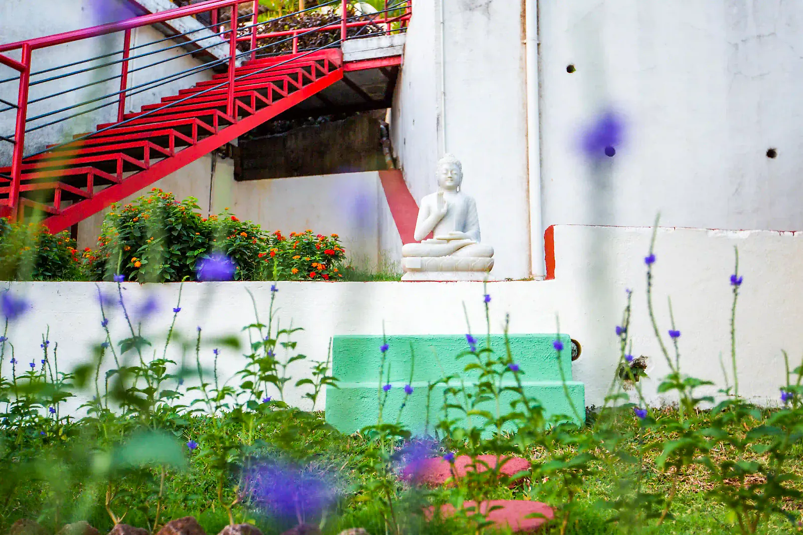 A white Buddha statue in the resort garden