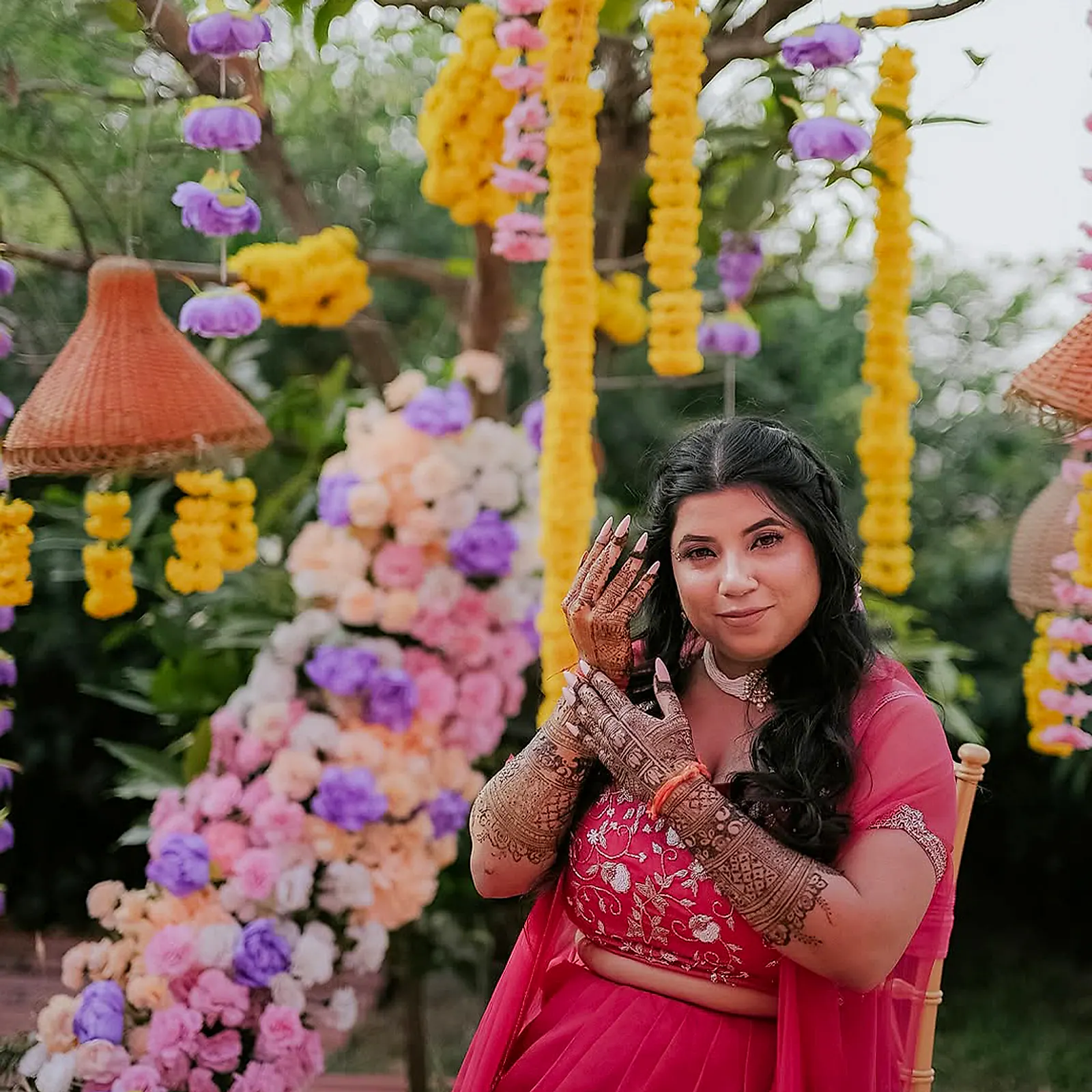 The bride showing her mehndi among lilac and marigold flowers